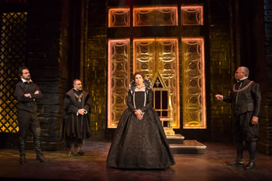 All in clothes of Tudor nobility, Leicester stands with his arms crossed, Burleigh is poised with hands clasped at his waist, Shrewsbury is extending his right hand as he makes a point, and Elizabeth stands in the center, hands folded at her waist. In the background is a throne against a golden carved wall, with the black brick pillars to either side. 